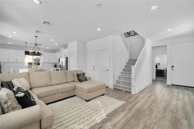 living room featuring light hardwood / wood-style flooring and an inviting chandelier