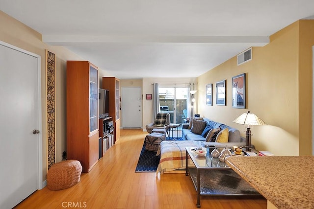 living room with beam ceiling and light hardwood / wood-style floors