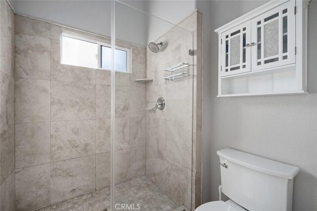 bathroom featuring toilet and tiled shower