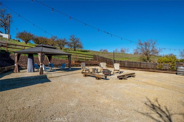 view of yard featuring a fire pit, a gazebo, and a patio