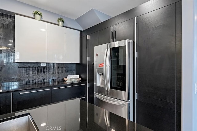 kitchen with decorative backsplash, stainless steel fridge, and white cabinets