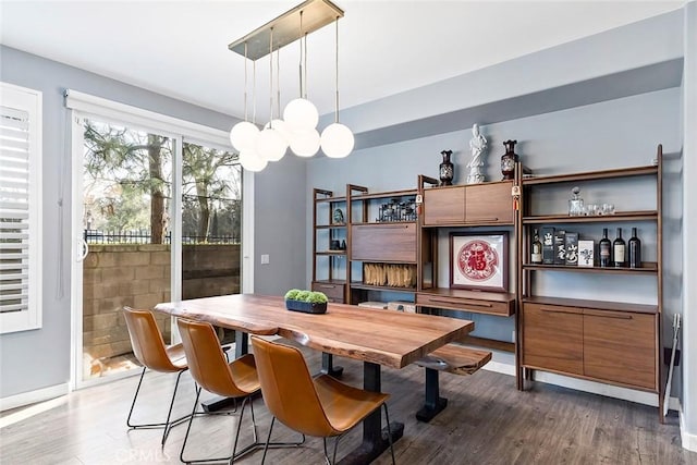 dining space featuring dark wood-type flooring and a notable chandelier