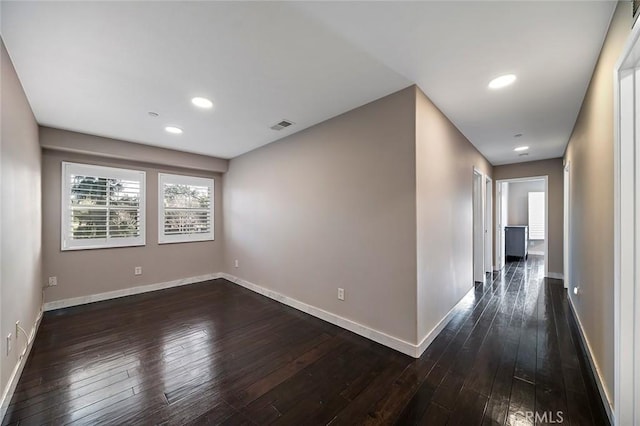 unfurnished room with dark hardwood / wood-style flooring