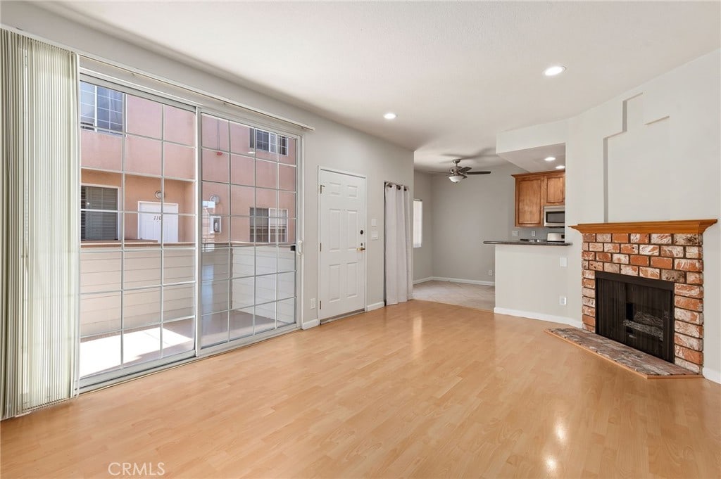 unfurnished living room featuring ceiling fan, light hardwood / wood-style flooring, and plenty of natural light