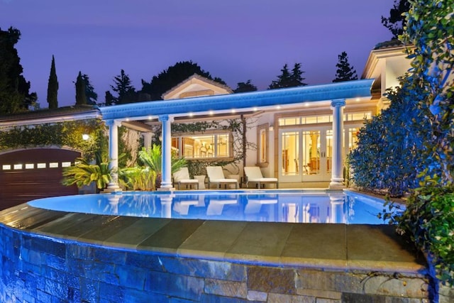 pool at dusk with french doors