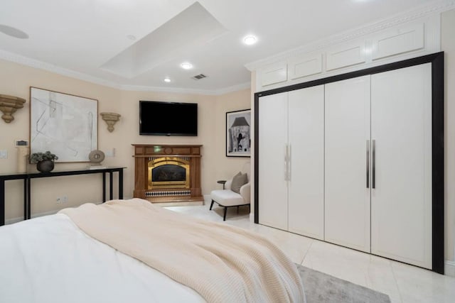 bedroom with crown molding, light tile patterned floors, and a closet