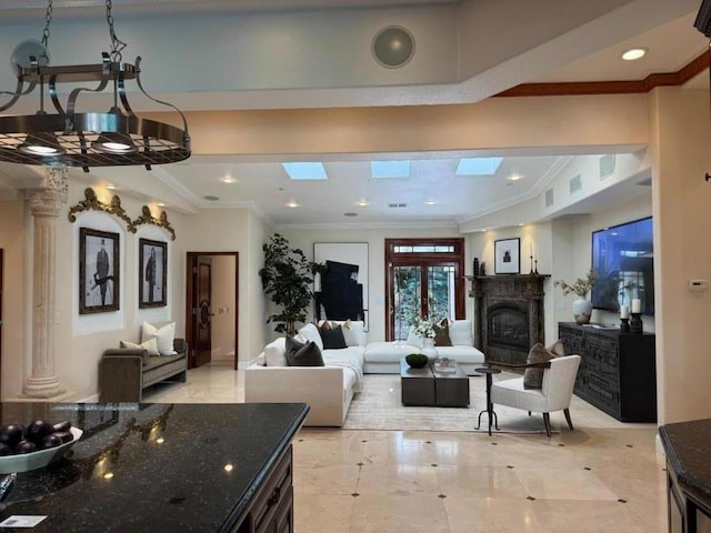 living room with a skylight, ornamental molding, and a chandelier