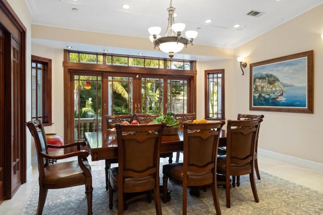 dining area with an inviting chandelier, ornamental molding, and french doors