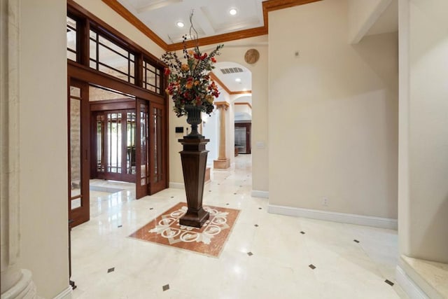 entrance foyer featuring a towering ceiling, ornamental molding, coffered ceiling, beam ceiling, and french doors