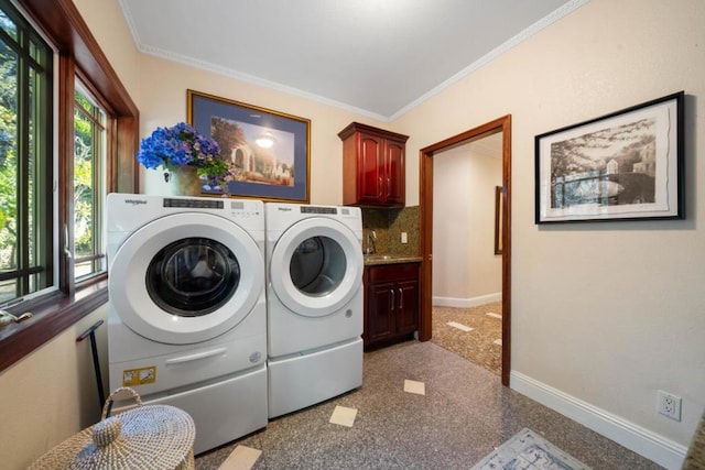 laundry area featuring sink, ornamental molding, washing machine and dryer, and cabinets