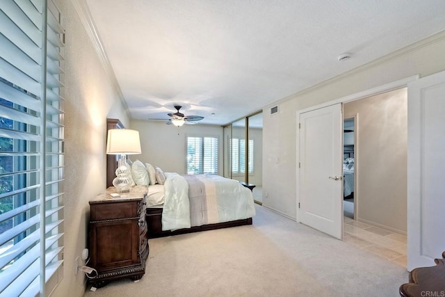 bedroom featuring light carpet, ornamental molding, and ceiling fan