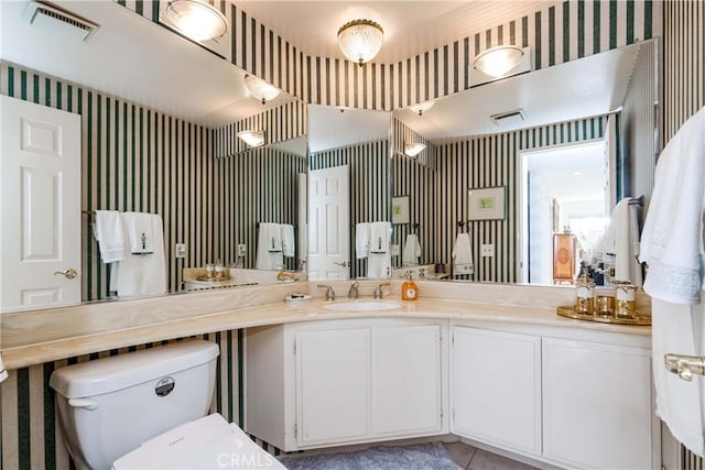 bathroom with vanity, toilet, and tile patterned flooring