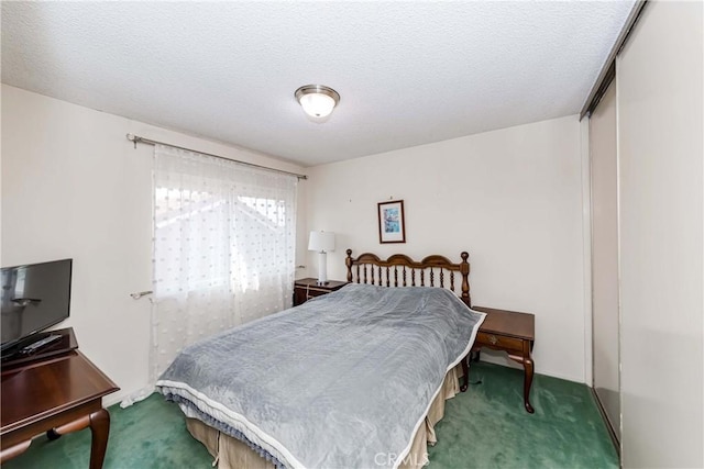 carpeted bedroom with a textured ceiling and a closet