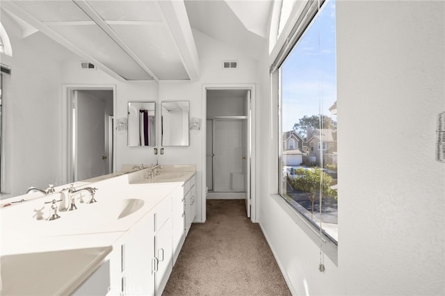 bathroom with a shower with shower door, lofted ceiling, and vanity