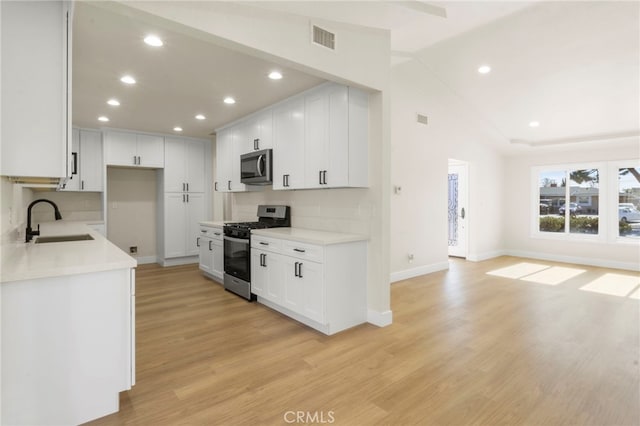 kitchen with stainless steel appliances, sink, and white cabinets