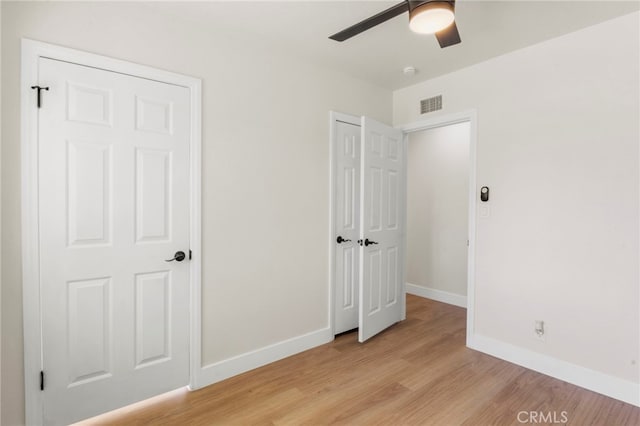 unfurnished bedroom featuring light wood-type flooring and ceiling fan