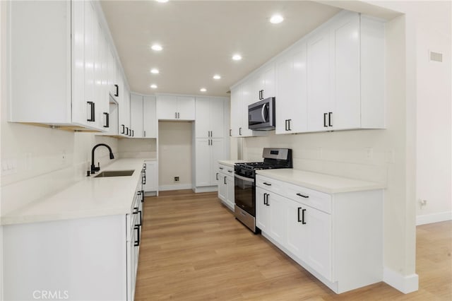 kitchen featuring sink, stainless steel appliances, and white cabinets