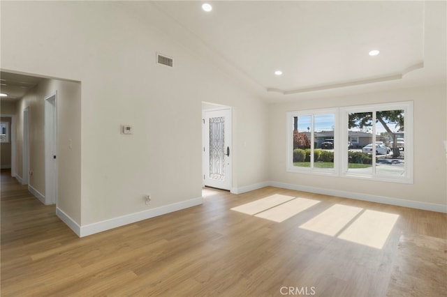 unfurnished living room featuring lofted ceiling and light wood-type flooring