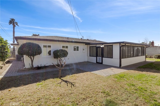 back of house featuring a yard, a patio area, and a sunroom