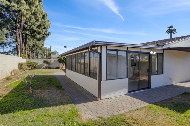 exterior space featuring a lawn and a sunroom