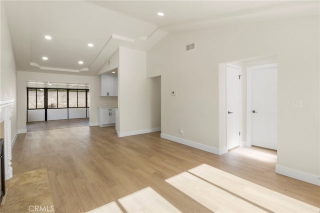 unfurnished living room with light hardwood / wood-style flooring and vaulted ceiling