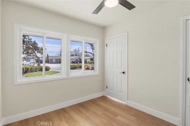 empty room with ceiling fan and light hardwood / wood-style floors