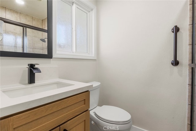 bathroom featuring vanity, an enclosed shower, and toilet