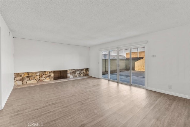 unfurnished living room with light hardwood / wood-style floors and a textured ceiling