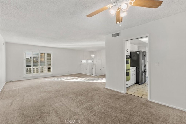 carpeted empty room with ceiling fan and a textured ceiling