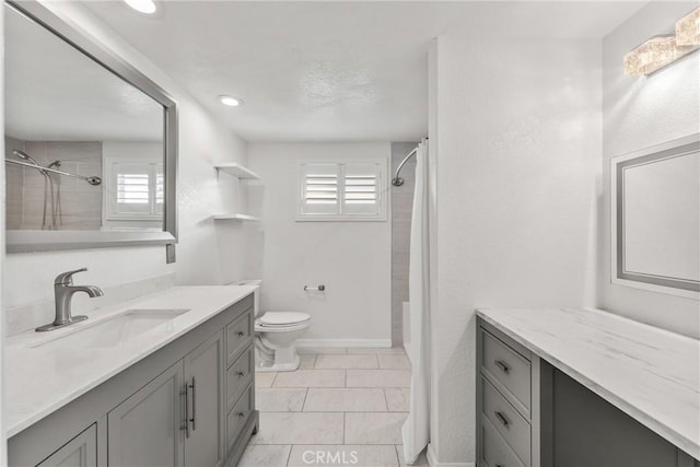 bathroom with a tile shower, toilet, and vanity