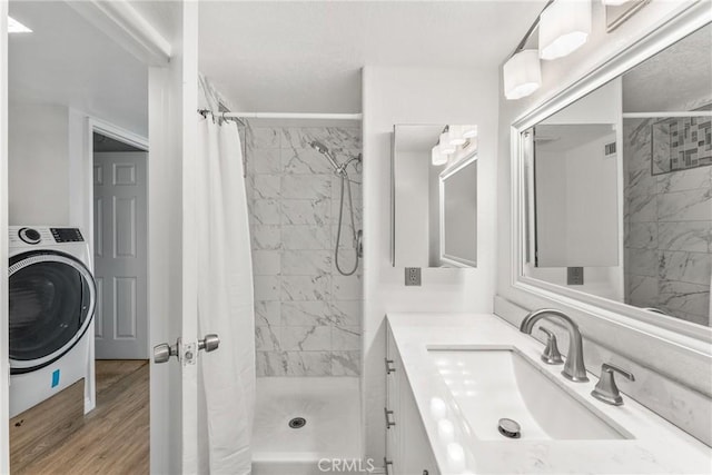 bathroom featuring hardwood / wood-style flooring, washer / dryer, vanity, and a shower with shower curtain