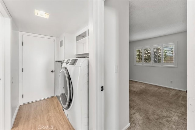 clothes washing area featuring washer and dryer and carpet