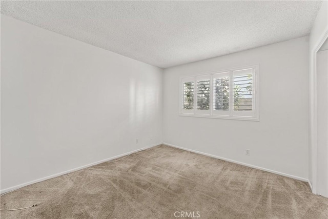 unfurnished room featuring a textured ceiling and carpet floors