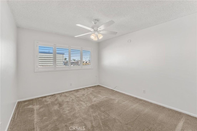 carpeted spare room with ceiling fan and a textured ceiling