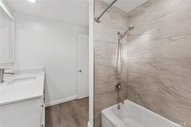 bathroom with vanity, wood-type flooring, and tiled shower / bath combo