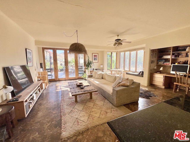 living room with built in desk, ceiling fan, and french doors