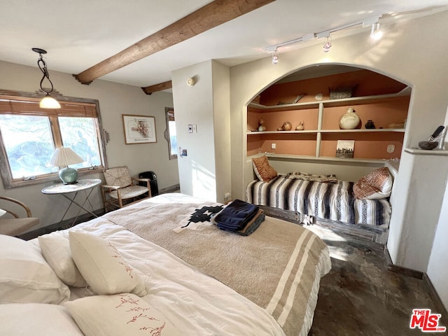 bedroom with beam ceiling and rail lighting