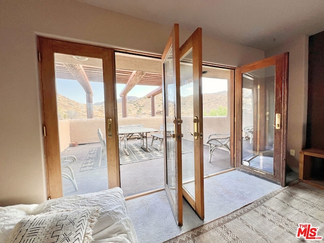 entryway with light carpet, a mountain view, and french doors