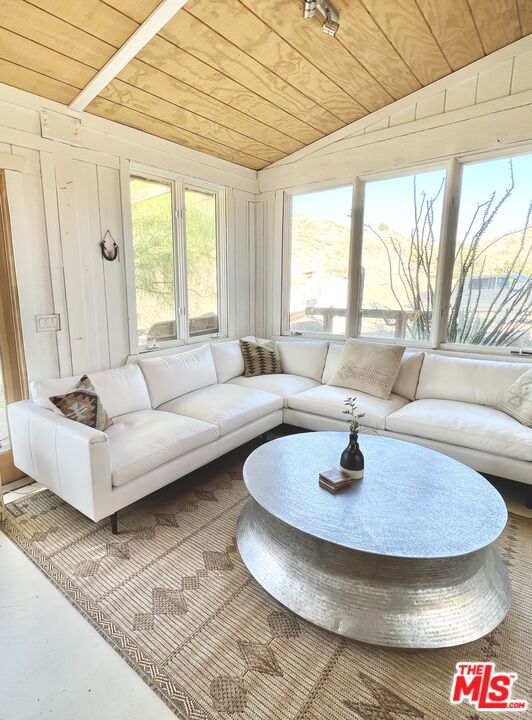 sunroom featuring vaulted ceiling and wood ceiling