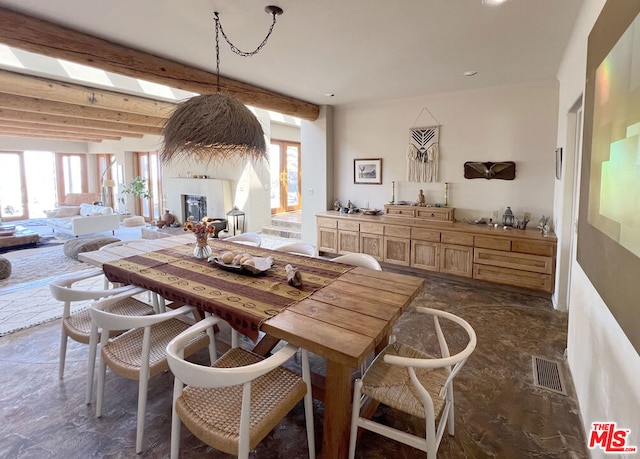 dining area featuring beamed ceiling