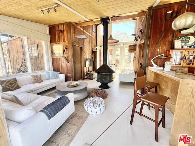 interior space with a wood stove, wooden walls, and wooden ceiling