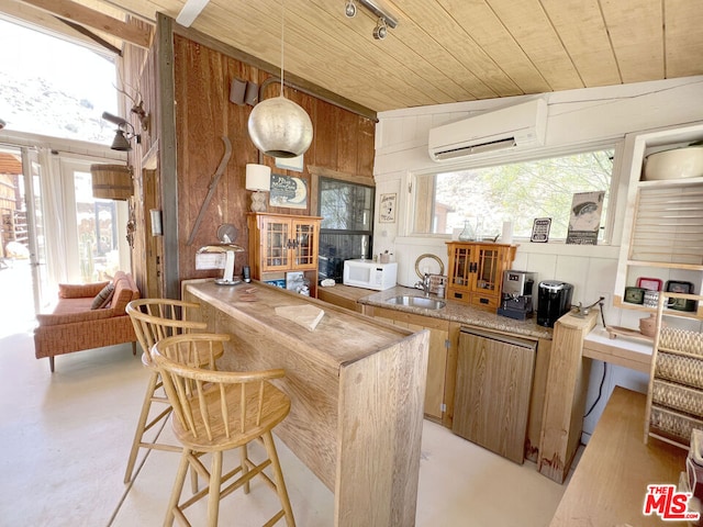 kitchen featuring wood ceiling, a healthy amount of sunlight, wood walls, vaulted ceiling, and a wall mounted air conditioner