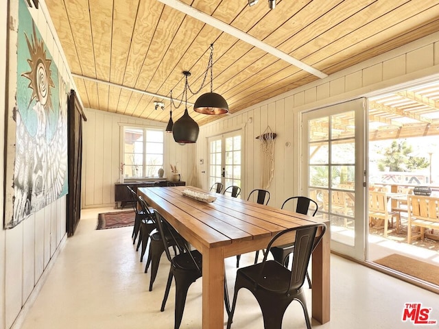 dining area featuring wooden ceiling, a wealth of natural light, wood walls, and french doors