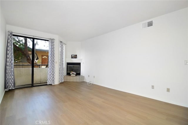 unfurnished room with wood-type flooring and a fireplace