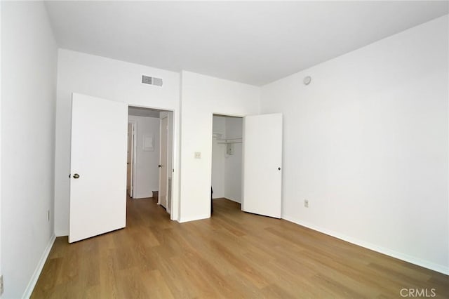 unfurnished bedroom with light hardwood / wood-style floors and a closet