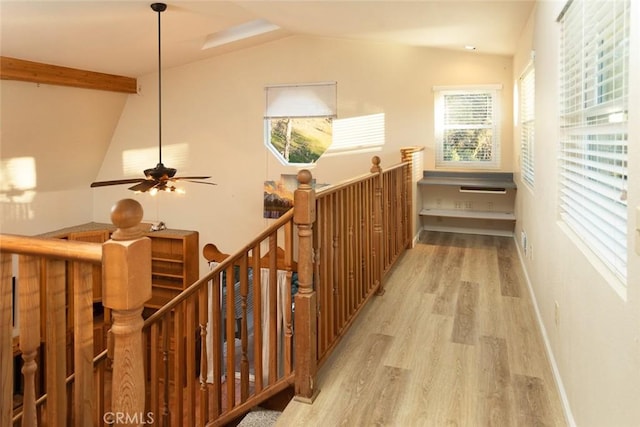 corridor featuring lofted ceiling with beams and light wood-type flooring