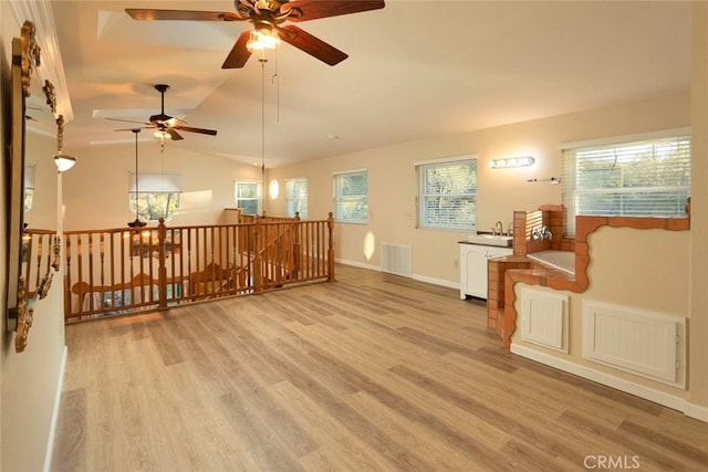 living room with lofted ceiling, sink, light hardwood / wood-style flooring, and a wealth of natural light