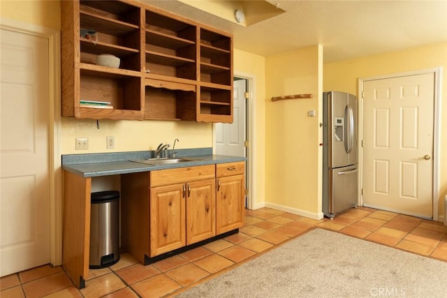 kitchen with stainless steel fridge with ice dispenser, light tile patterned floors, and sink