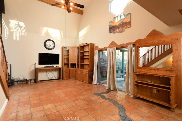 tiled living room featuring ceiling fan and high vaulted ceiling