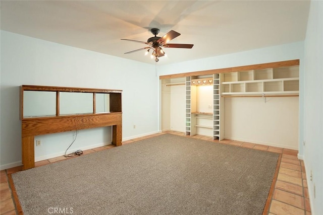 unfurnished bedroom with tile patterned flooring, ceiling fan, and a closet